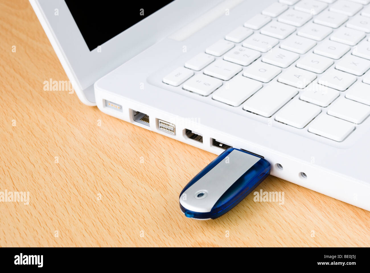 Laptop e flash USB pen drive disposti sul tavolo in legno Foto Stock