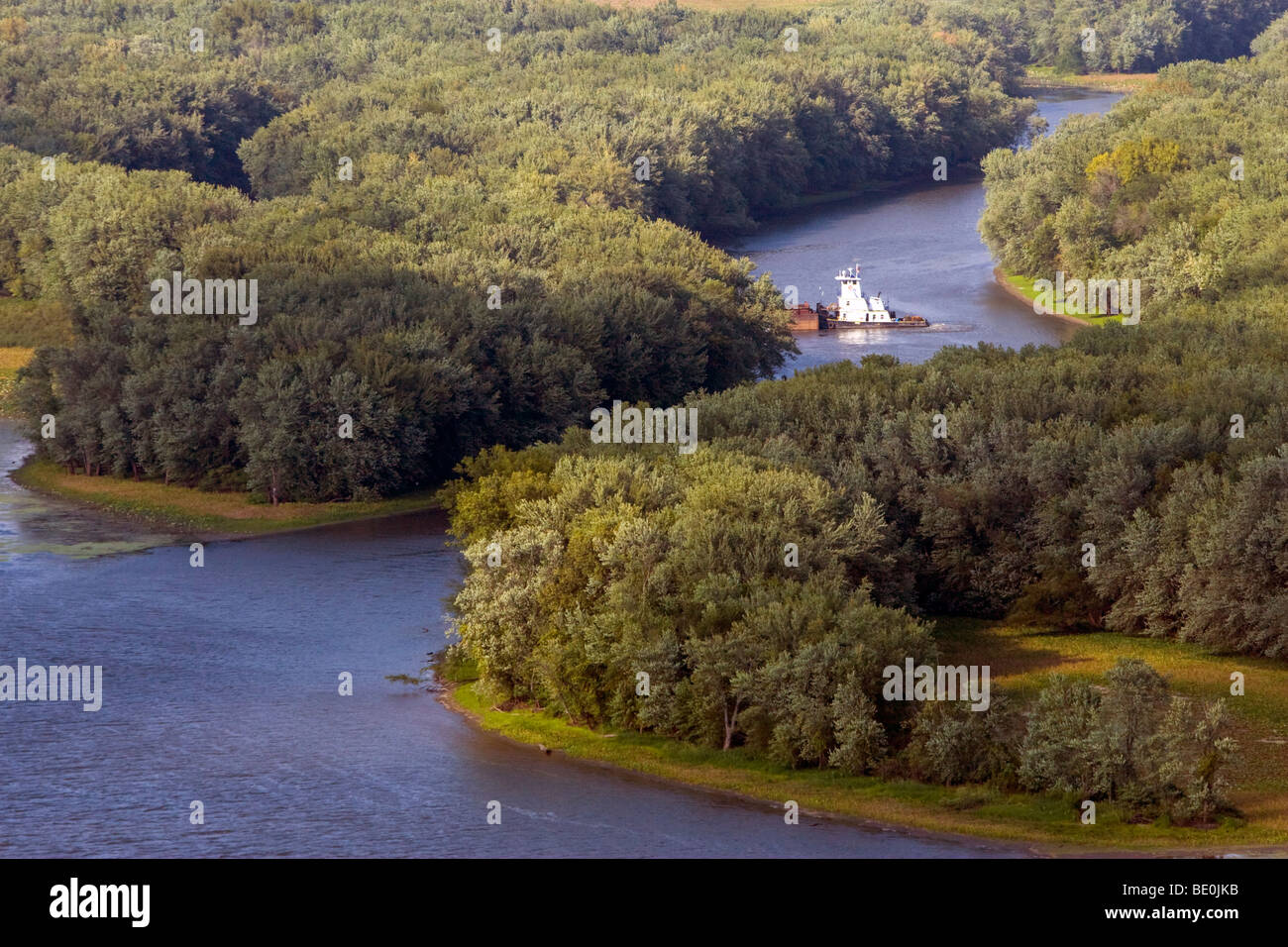 La navigazione di basse lagune del fiume Mississippi, una piccola towboat spinge un paio di chiatte in una calda giornata di caduta. Foto Stock