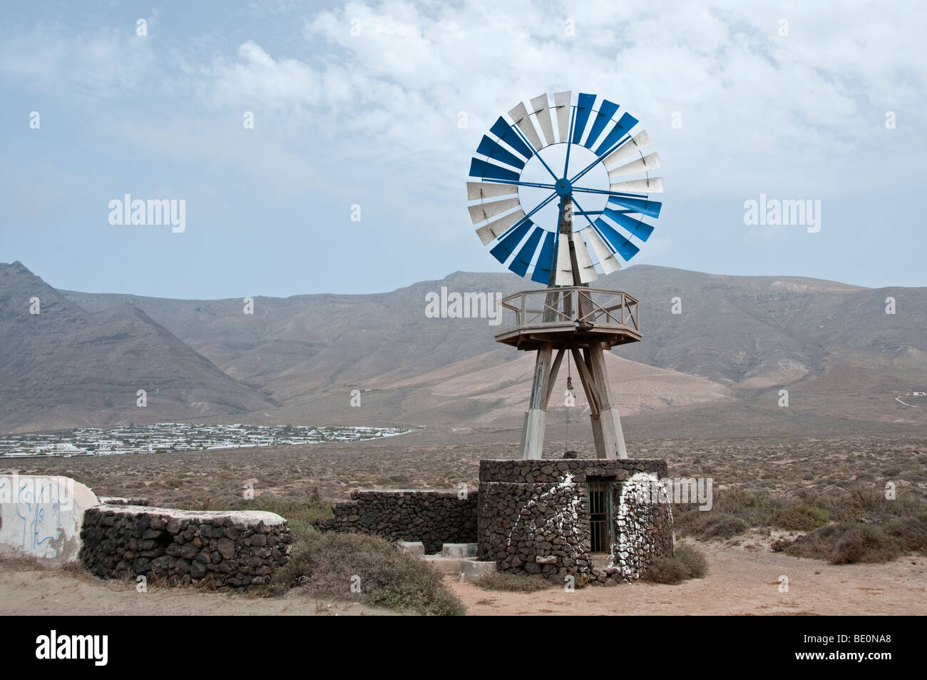 Mulino a vento su un pozzo in pietra per il pompaggio di acqua, Lanzarote, Isole Canarie. Foto Stock