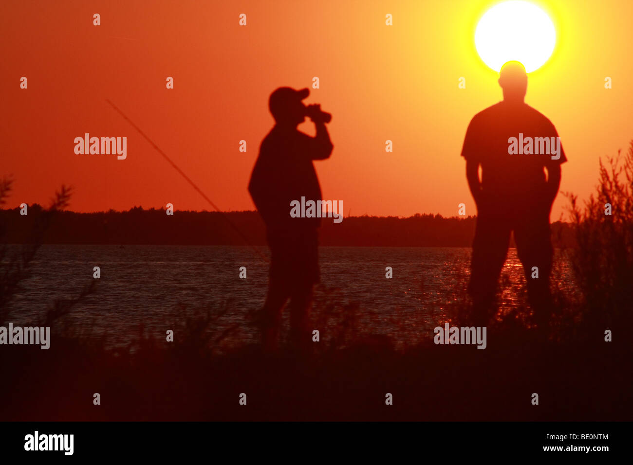 La pesca al tramonto sulla diga del Danubio canale in Slovacchia Foto Stock