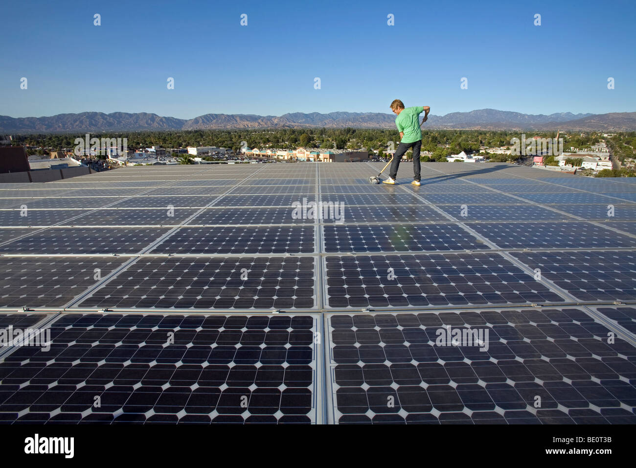 Pulizia dei pannelli solari. Array sul tetto dell'edificio per uffici nella città di Panorama, Valle di San Fernando, Los Angeles, California, Stati Uniti d'America Foto Stock