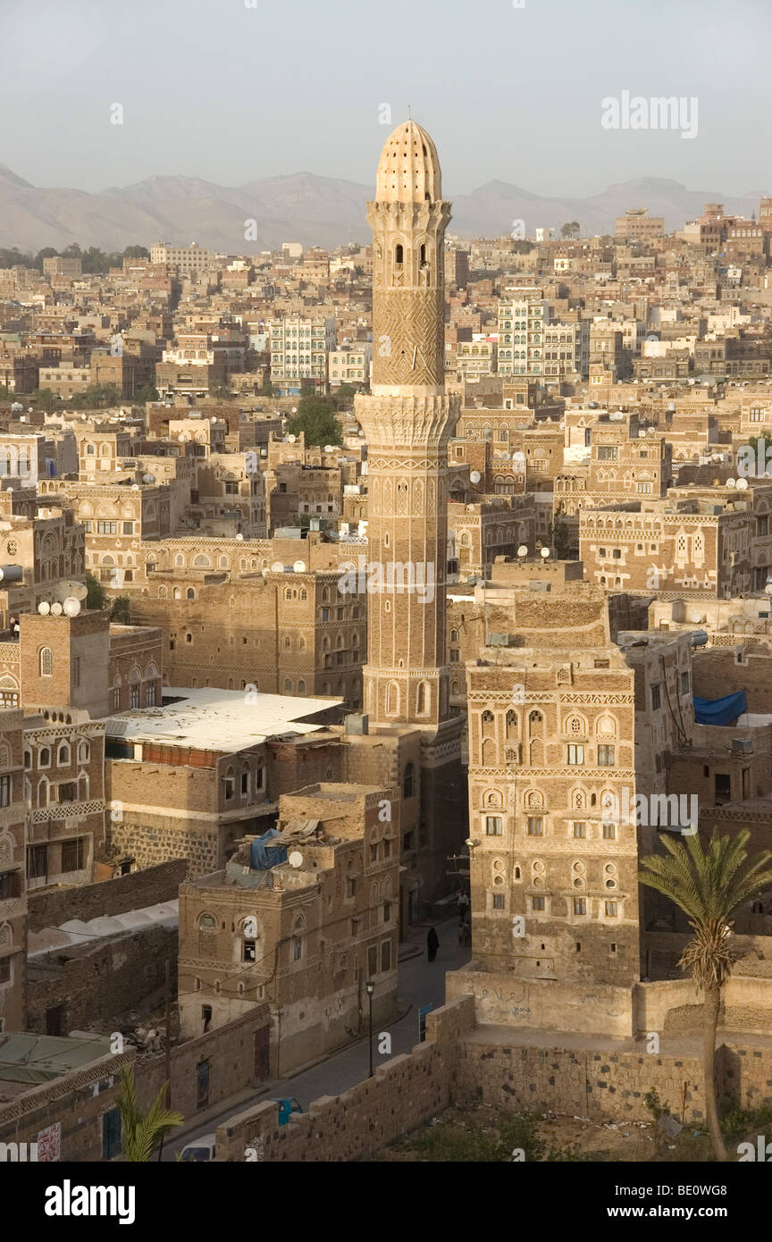 Un minareto e le tradizionali case a torre dello skyline della città vecchia di Sana'a, Yemen. Foto Stock