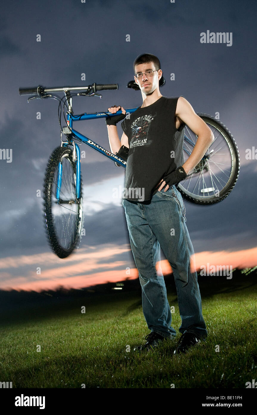 Adolescente con la sua mountain bike fotografato con otturatore trascinare. Foto Stock