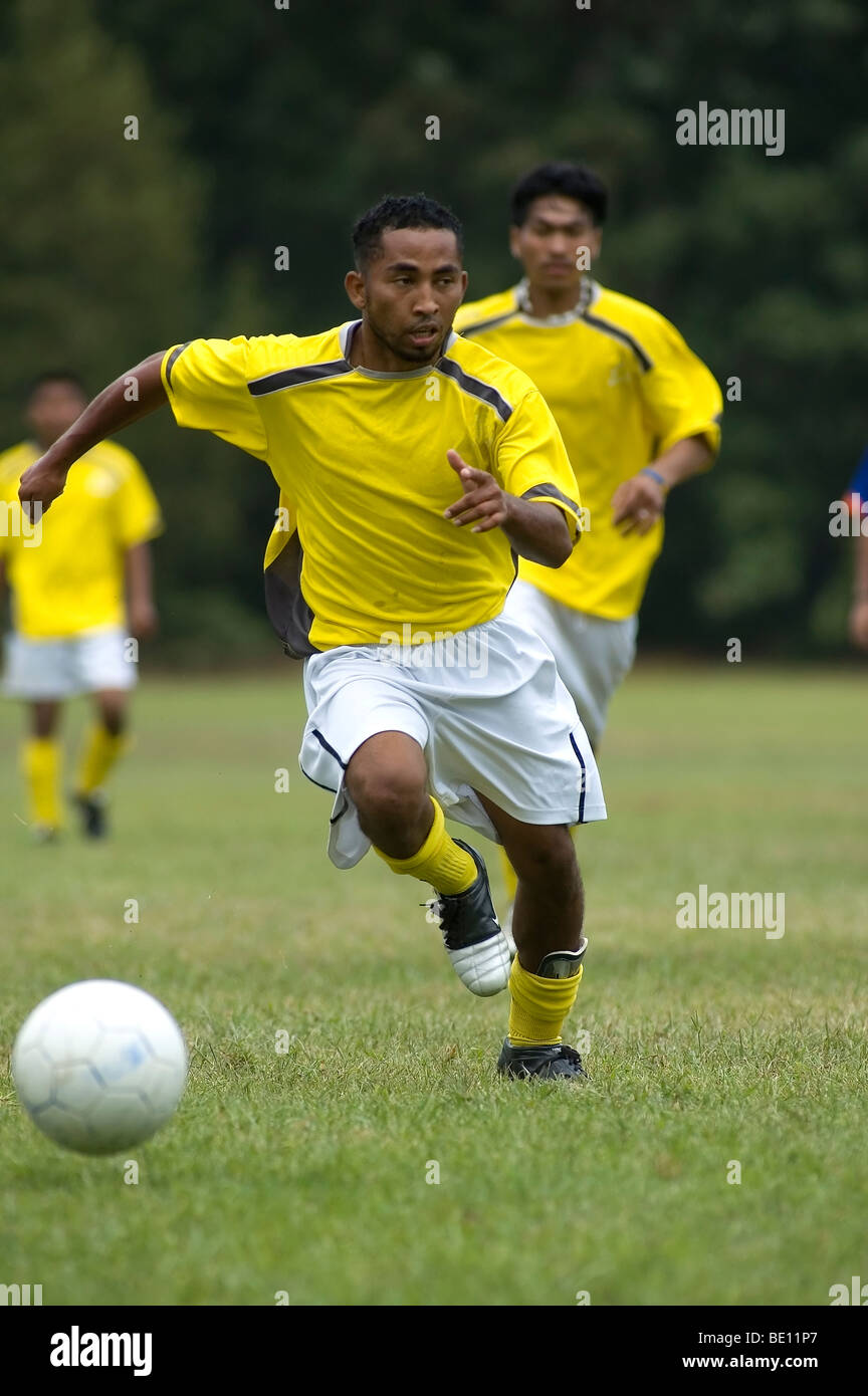 Giocatore di calcio rigidi con la sfera verso il basso campo. Foto Stock