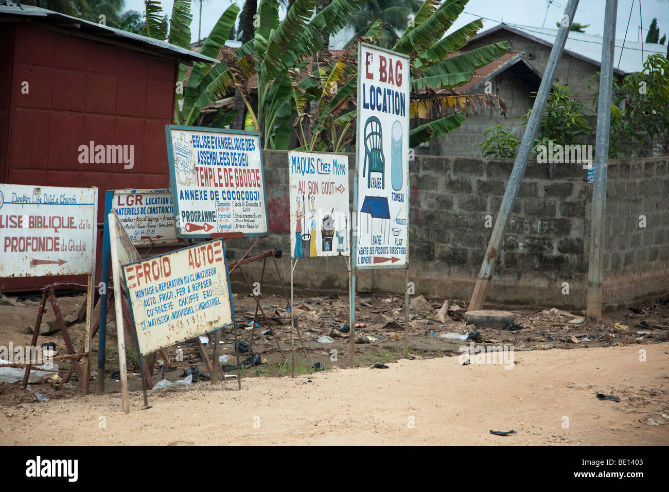 Linea di segni per le strade di Cotonou, Benin.a causa degli elevati tassi di analfabetismo, molti segni pubblicizzare attraverso le immagini. Foto Stock