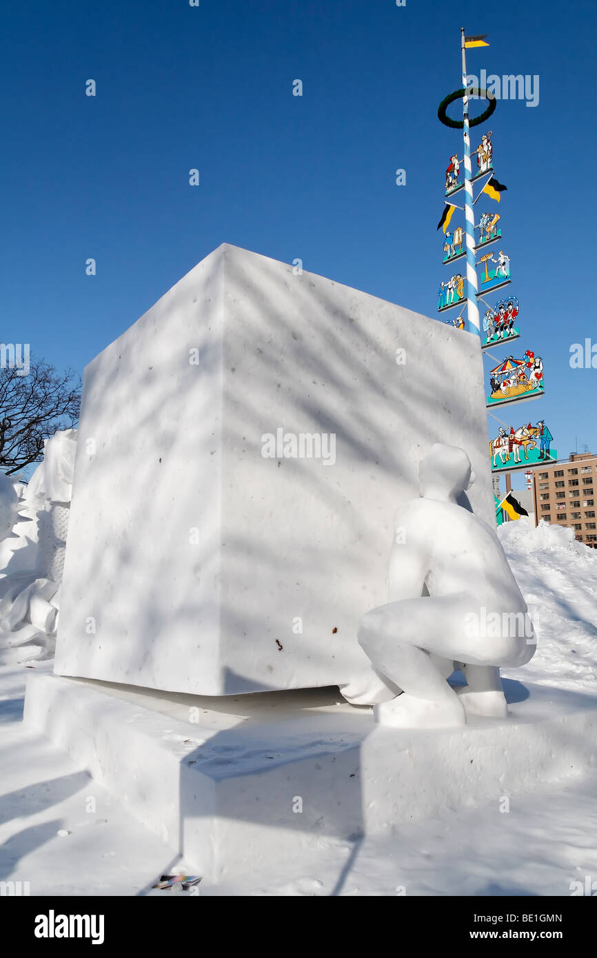 Uomo di sollevamento di un blocco gigante - scultura di neve a Sapporo Snow Festival. Foto Stock