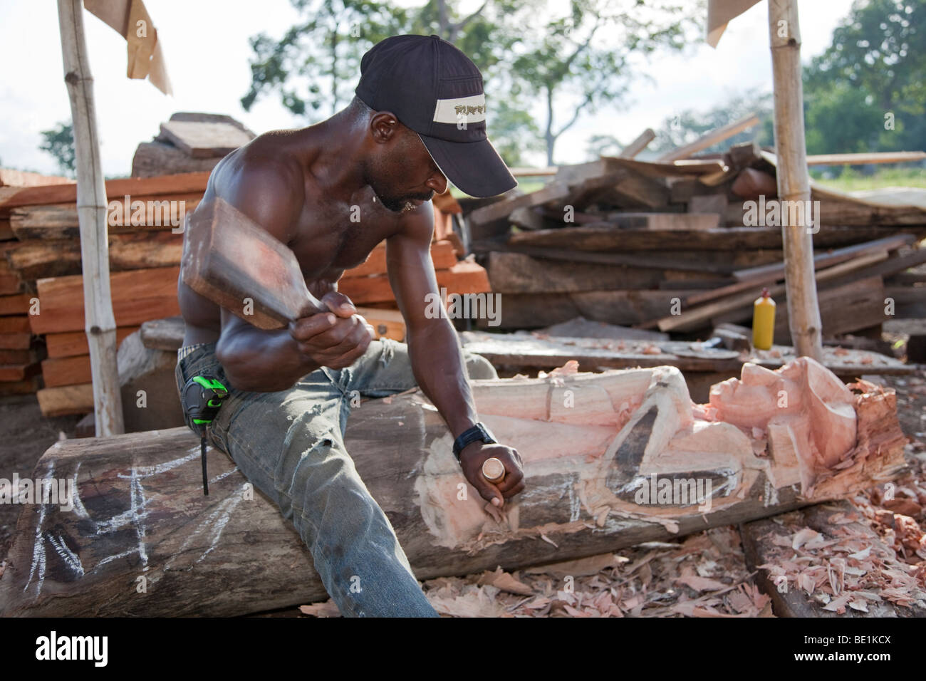 Un uomo fa sculture in legno in Nigeria la città capitale di Abuja. Foto Stock