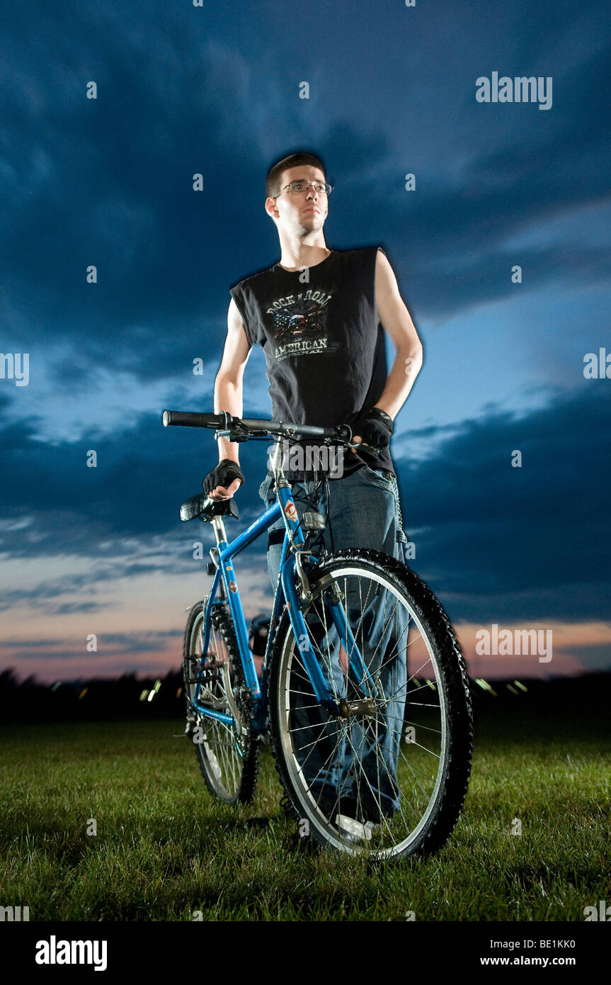 Adolescente con la sua mountain bike fotografato con otturatore trascinare. Foto Stock