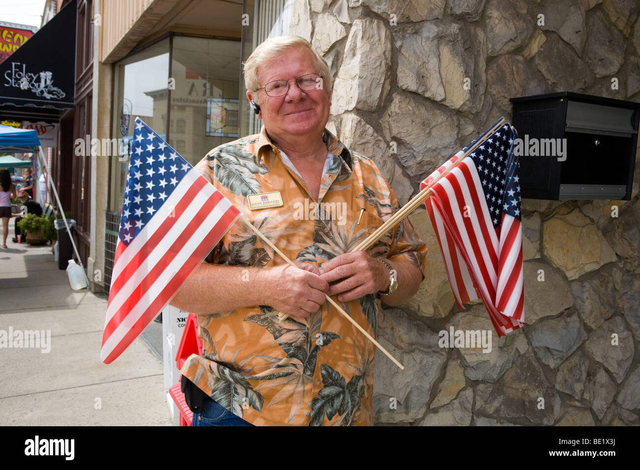 Uomo con le bandiere in una fiera di strada in La Grande Oregon Foto Stock