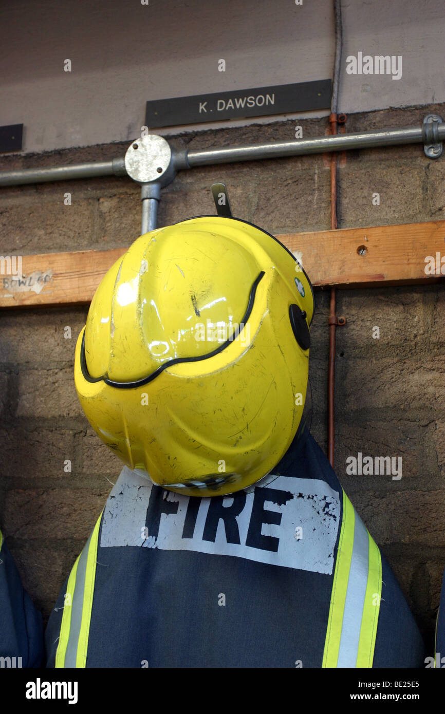 Fire Fighter uniformi della appesi in una stazione dei vigili del fuoco Foto Stock