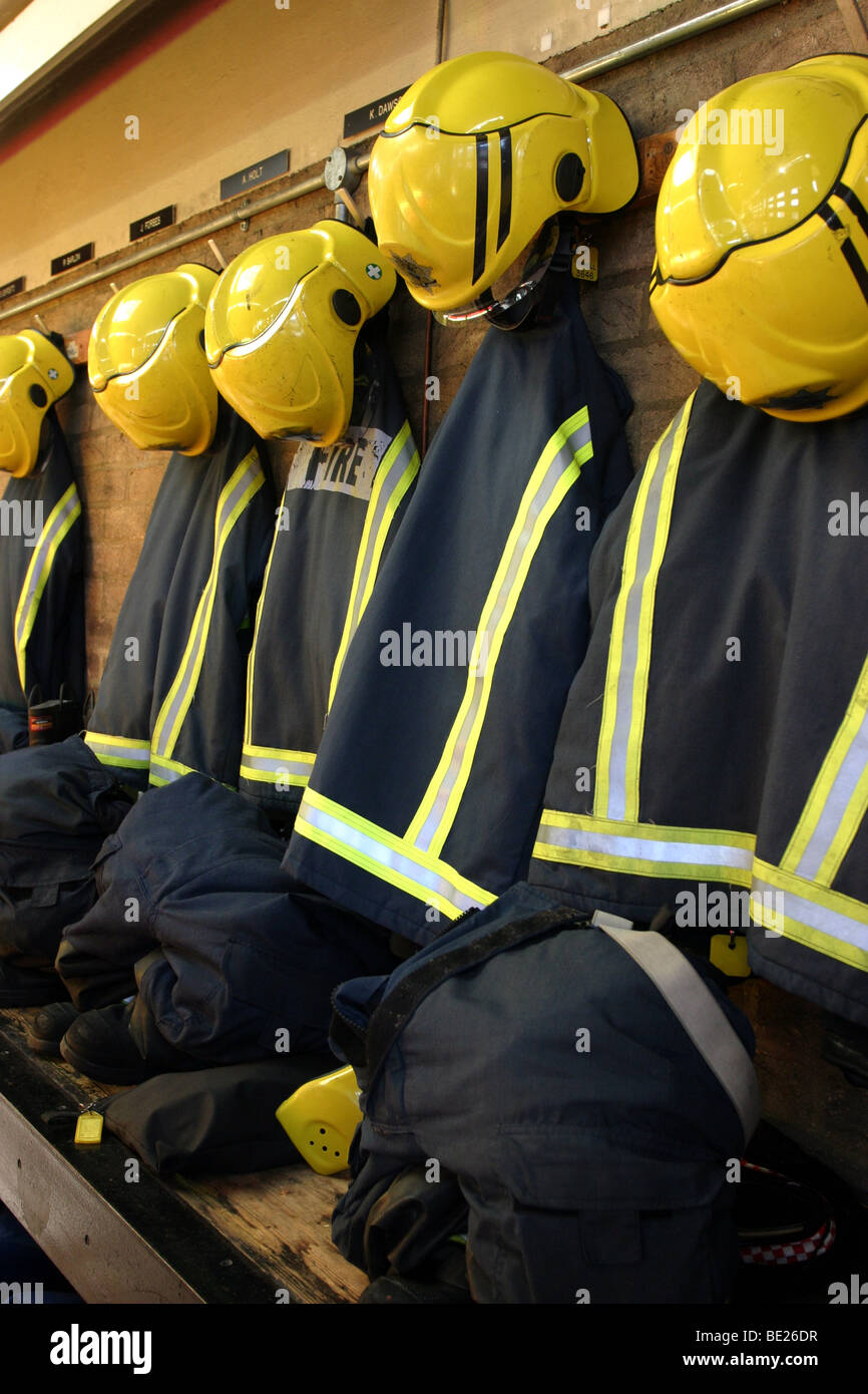 Fire Fighter uniformi appesi in una stazione dei vigili del fuoco Foto Stock