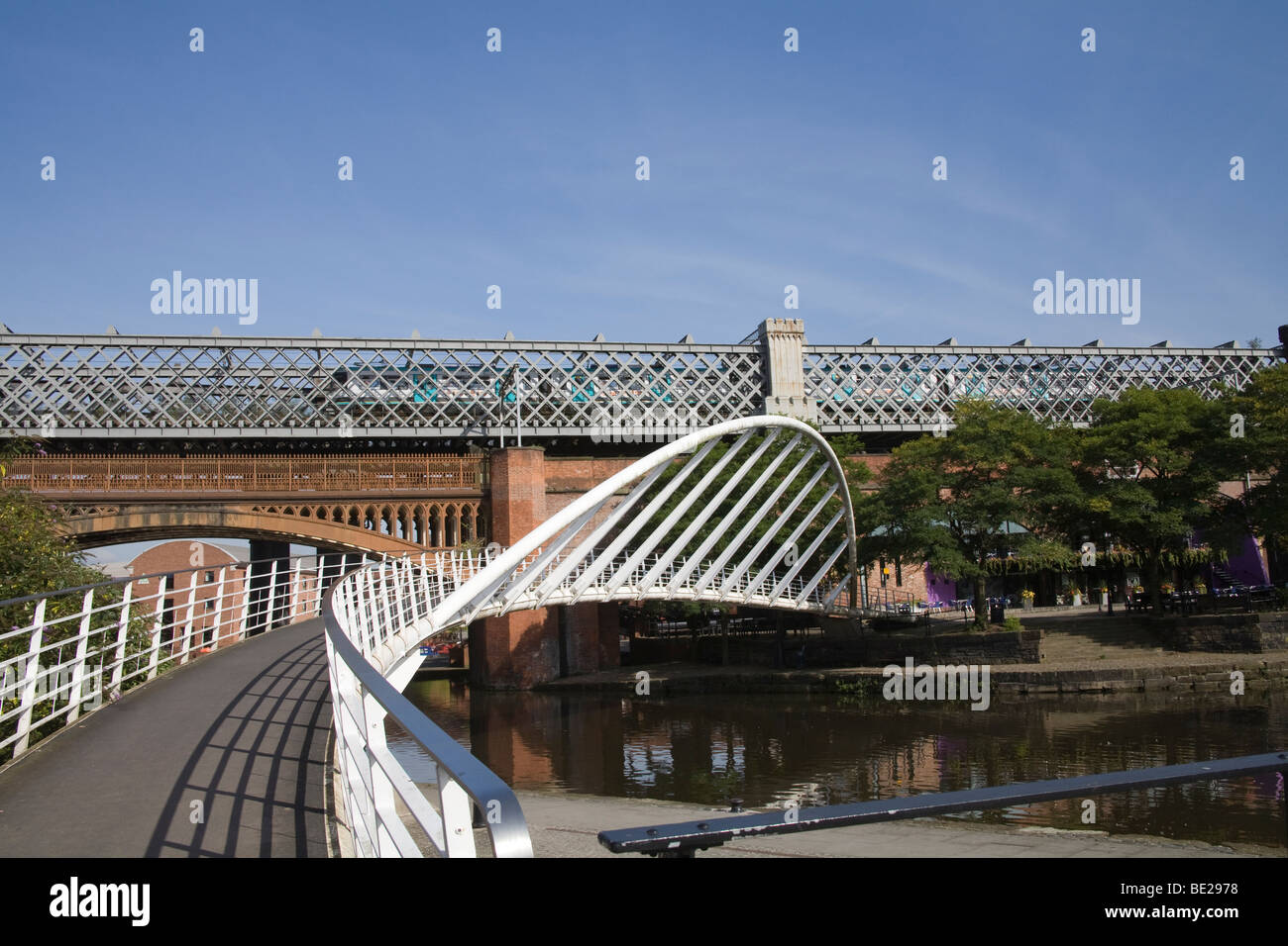 Manchester Inghilterra passerella pedonale oltre il gigantesco bacino del canale e i ponti ferroviari a Castlefields area della città il primo al mondo urban heritage park Foto Stock