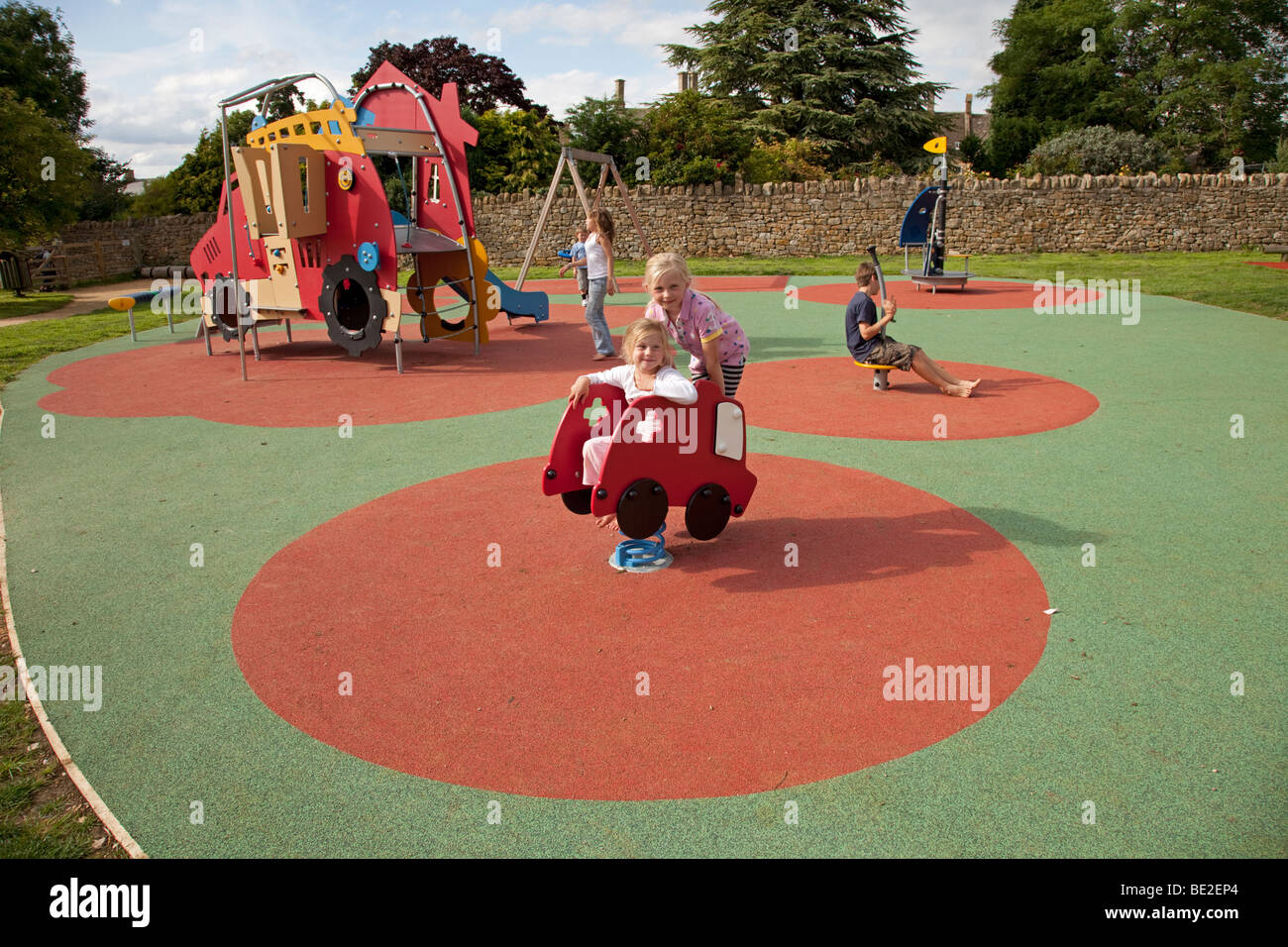 Ragazza che gioca la sicurezza attività di gomma materassino sul parco giochi a Broadway Activity Park WORCESTERSHIRE REGNO UNITO Foto Stock