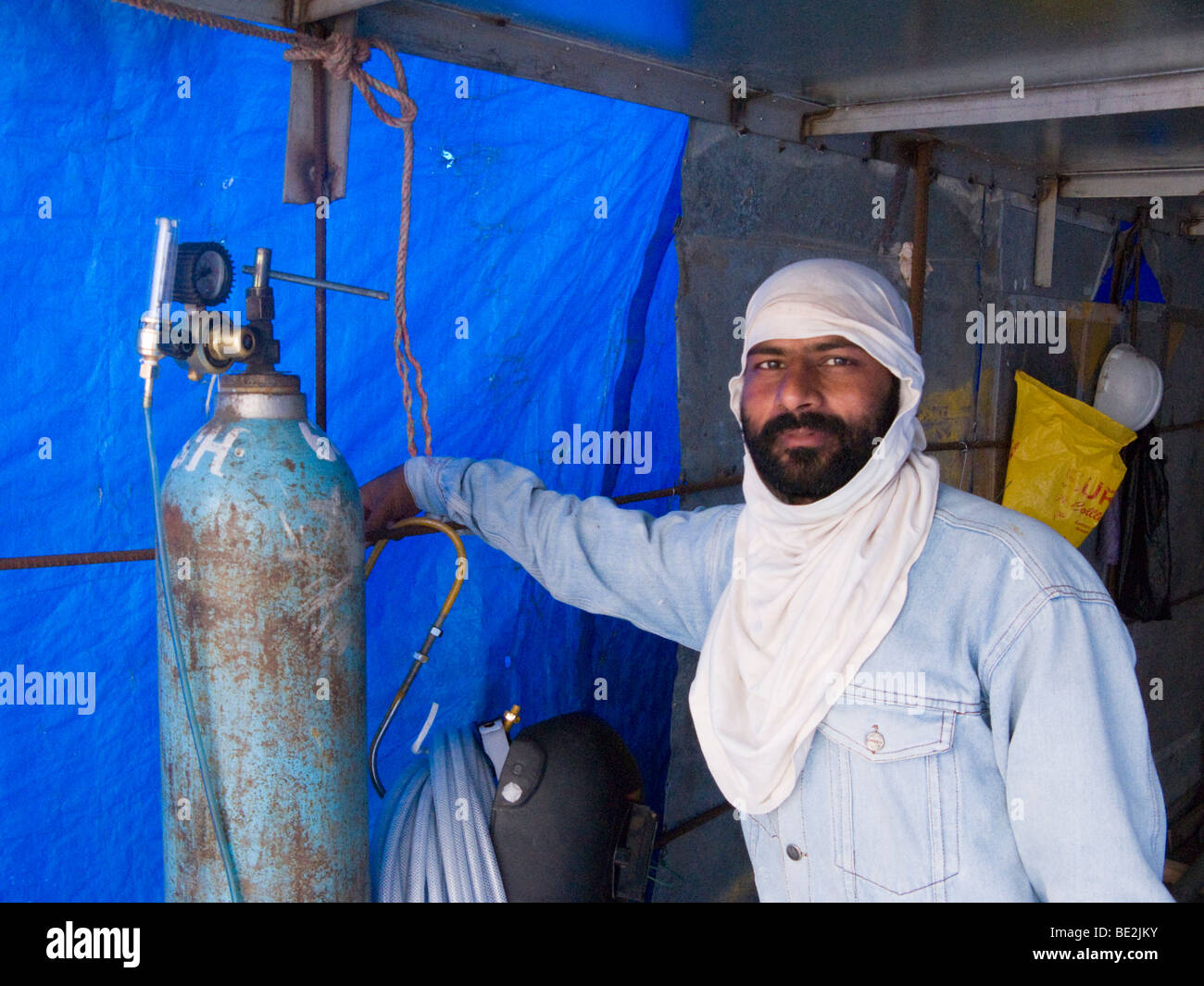 Un indiano operaio edile / saldatore con un cilindro di gas compresso - argon - Surat, Gujarat. India. Foto Stock