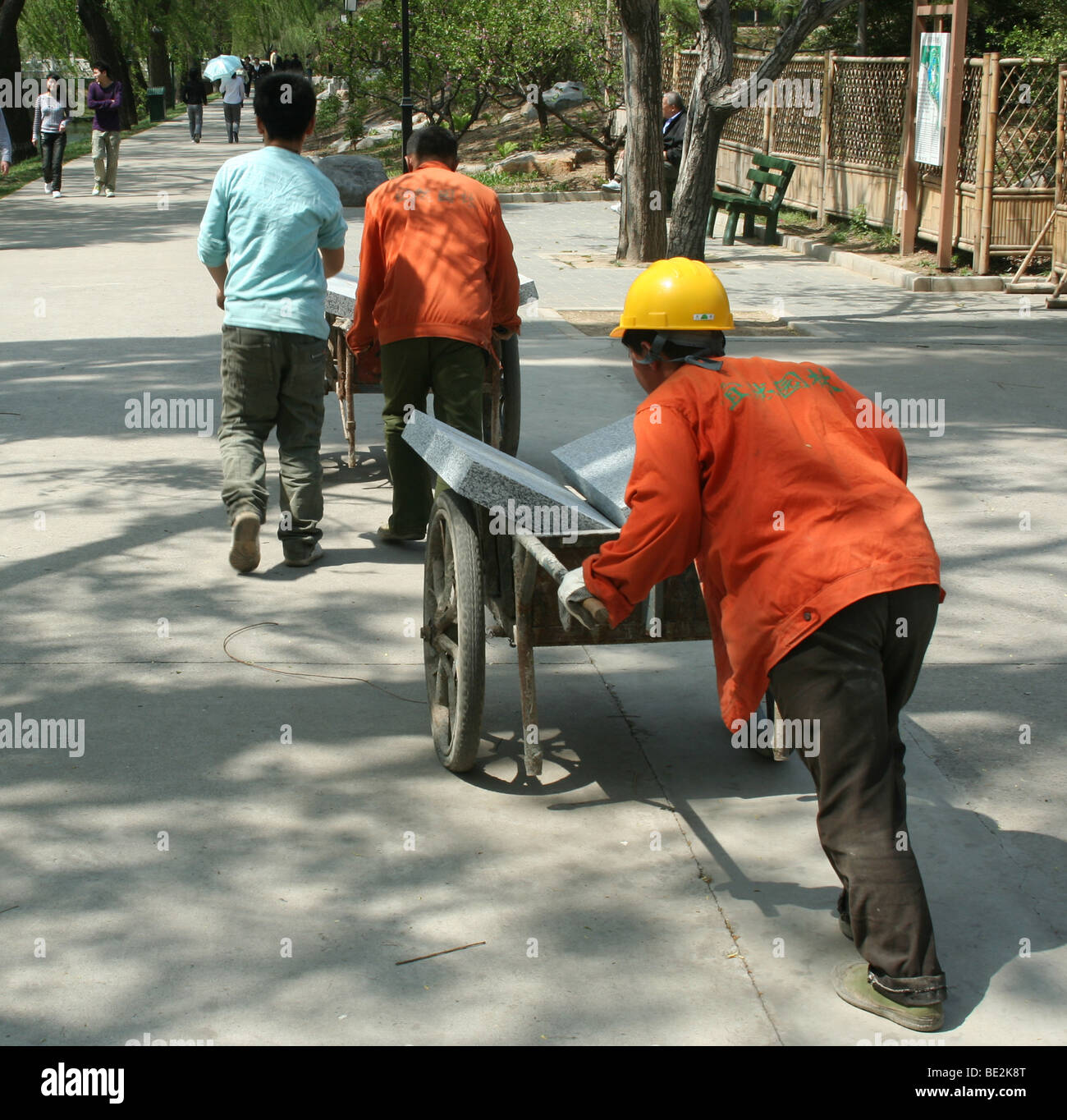 Lavoratori cinesi materiali di spinta nel parco di Pechino Foto Stock