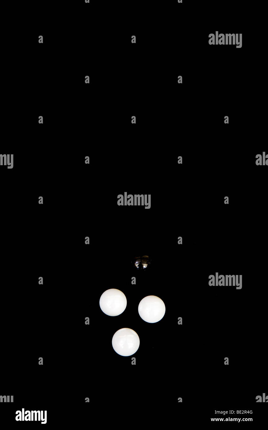 Il bianco e il nero sfere/marmi su sfondo nero Foto Stock