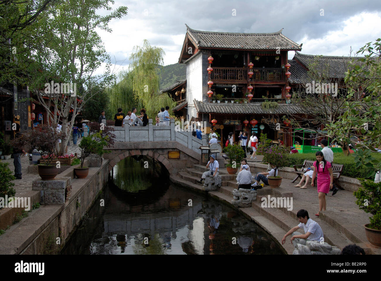 Molte persone in corrispondenza di un canale e il ponte, pittoresca città storica, il vecchio mercato, Lijiang, Sito Patrimonio Mondiale dell'UNESCO, Yunnan Pr Foto Stock