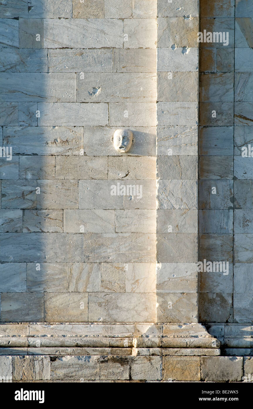 una maschera allegorica in pietra scolpita su un muro Foto Stock