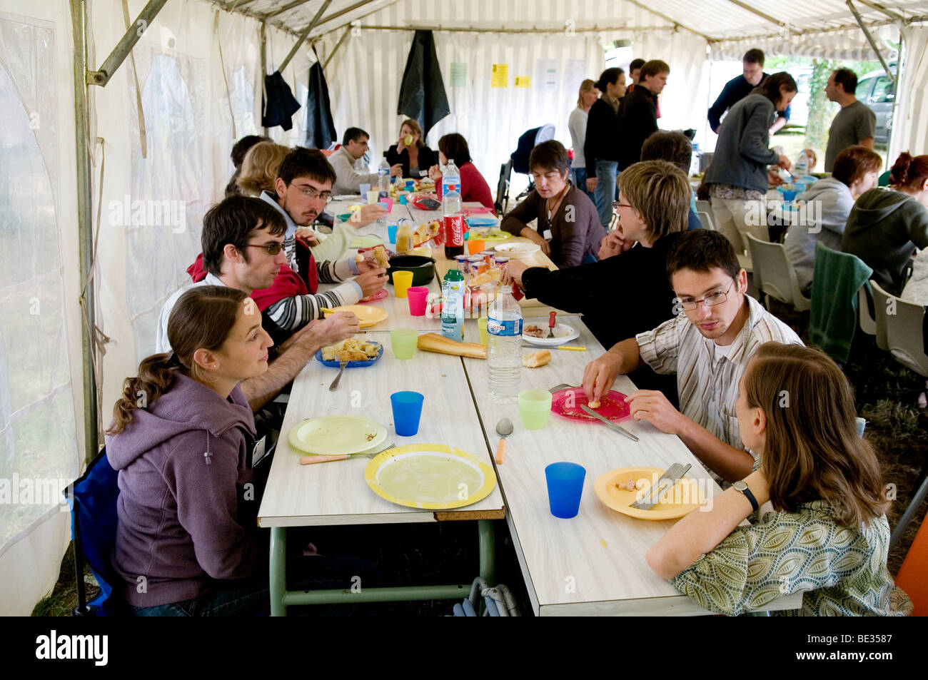Gruppo di persone che condividono un pasto presso un campeggio Foto Stock