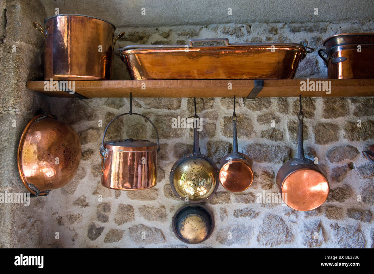 Una gamma di ottone pentole e padelle in un chateau francese cucina Foto Stock
