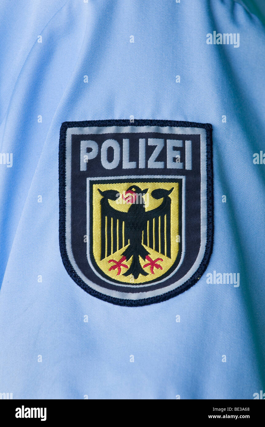 Badge di polizia con aquila federale sul manicotto di una camicia blu Foto Stock