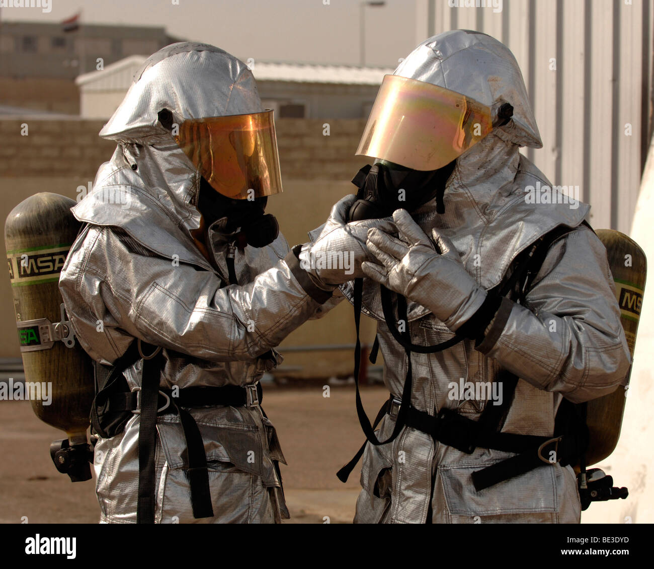 Un vigile del fuoco iracheno doppi controlli del suo partner equipaggiamento protettivo personale. Foto Stock