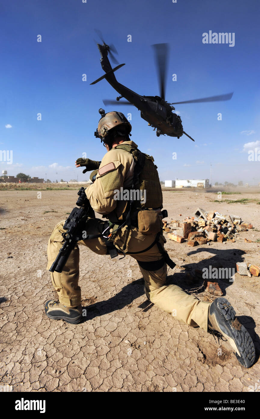 Un soldato conduce la sicurezza per un HH-60 Pavehawk elicottero. Foto Stock