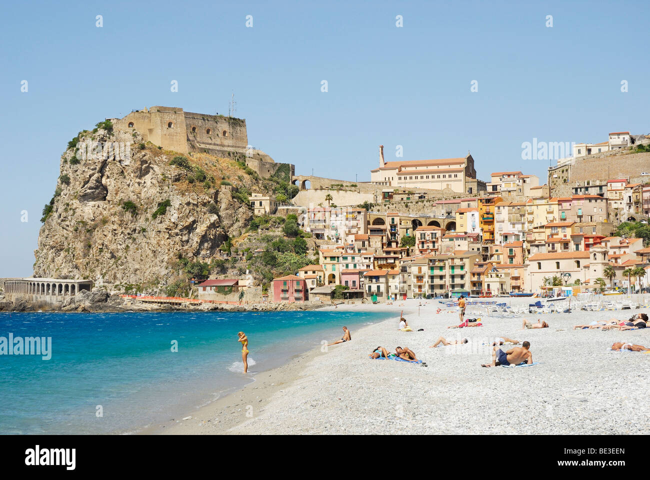 Persone su una spiaggia, città vecchia con il castello nel retro, sulla ripida scogliera costiera, Mar Tirreno, Scilla, Calabria, Sud Italia, Eur Foto Stock