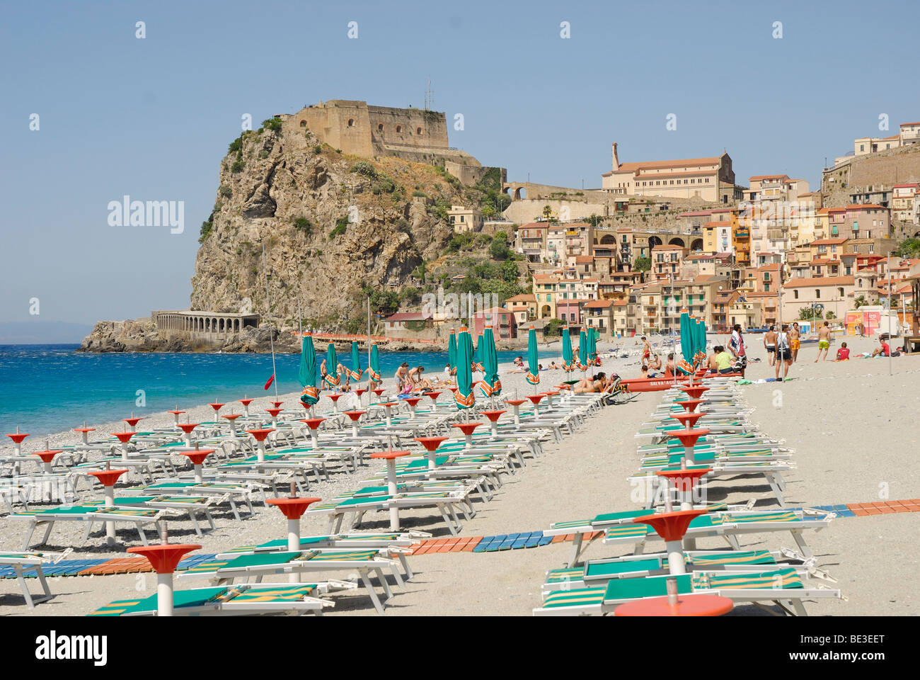 Sedie a sdraio sulla spiaggia, la città vecchia con il castello nel retro, sulla ripida scogliera costiera, Mar Tirreno, Scilla, Calabria, Sud Italia Foto Stock