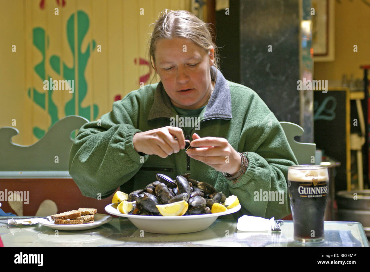 Ritratto di una giovane donna di mangiare conchiglie di mare, nella contea di Kerry, Repubblica di Irlanda Foto Stock