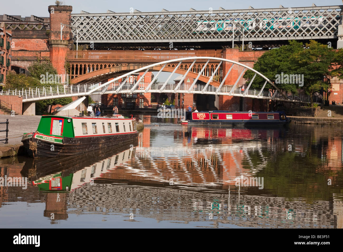 La Bridgewater Canal bacino narrowboats riflettente e mercanti e ponte nella zona di conservazione. Castlefield Urban Heritage Park, Manchester, Inghilterra, Regno Unito Foto Stock