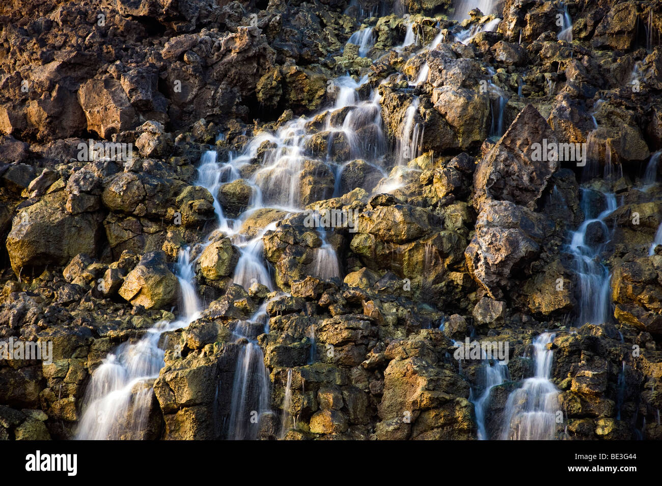 Soluzione salina cade dalla roccia vulcanica drop off per un flusso di runoff. Foto Stock