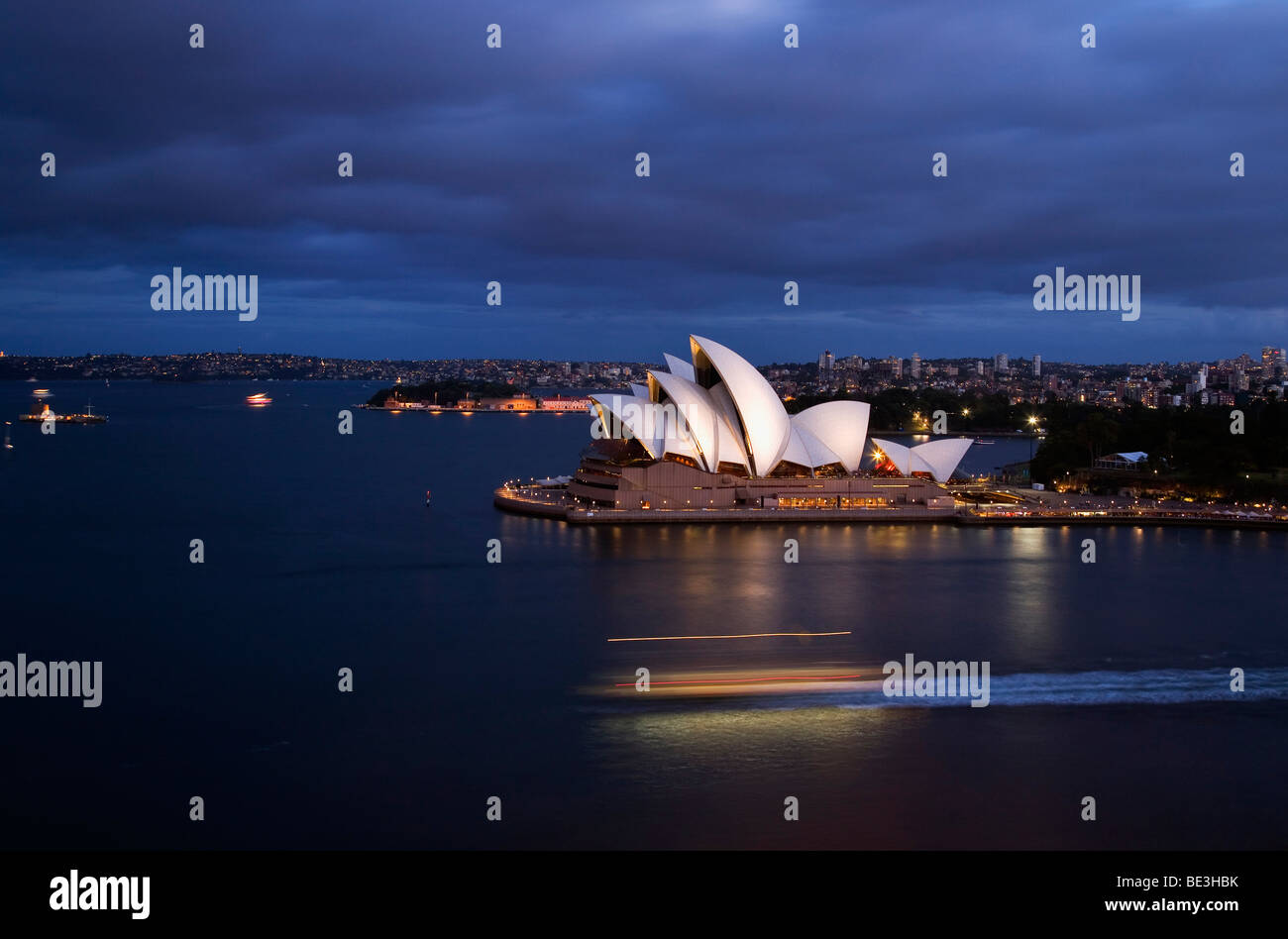 Un traghetto attraversa il porto di Sydney con la Opera House al tramonto. Sydney, Nuovo Galles del Sud, Australia Foto Stock