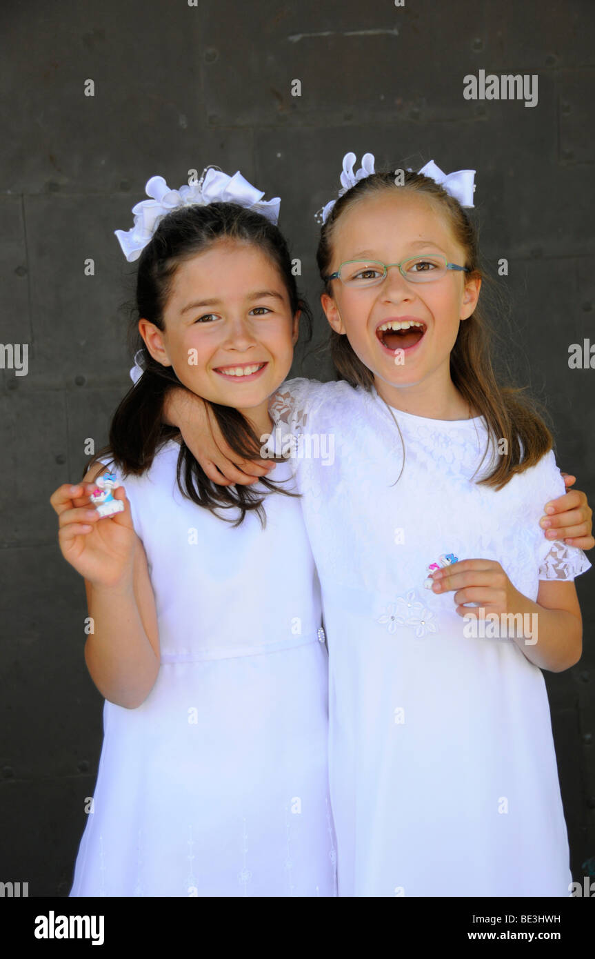 Le ragazze sono felice circa i loro piccoli regali per la Prima Comunione Foto Stock