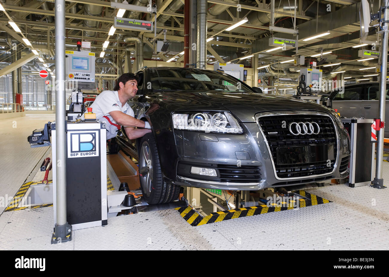 Un Audi dipendente che lavora sulla sospensione di set-up di un'Audi A6 Avant S-Line al centro di controllo dell'impianto di Audi in Neckars Foto Stock