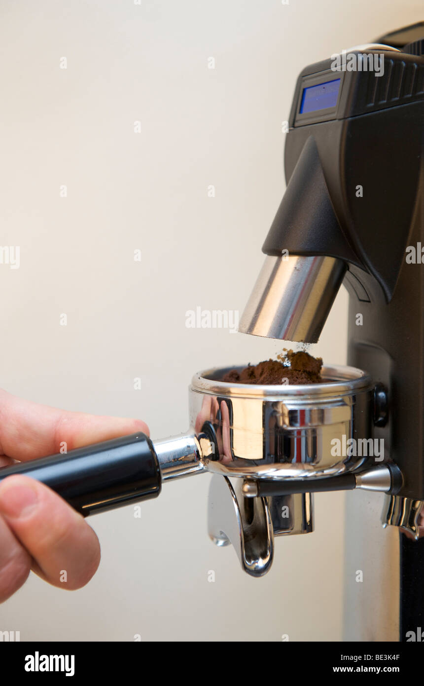 La preparazione professionale di espresso con una macchina espresso: Fase 1 - macinazione espresso nel filtro Foto Stock