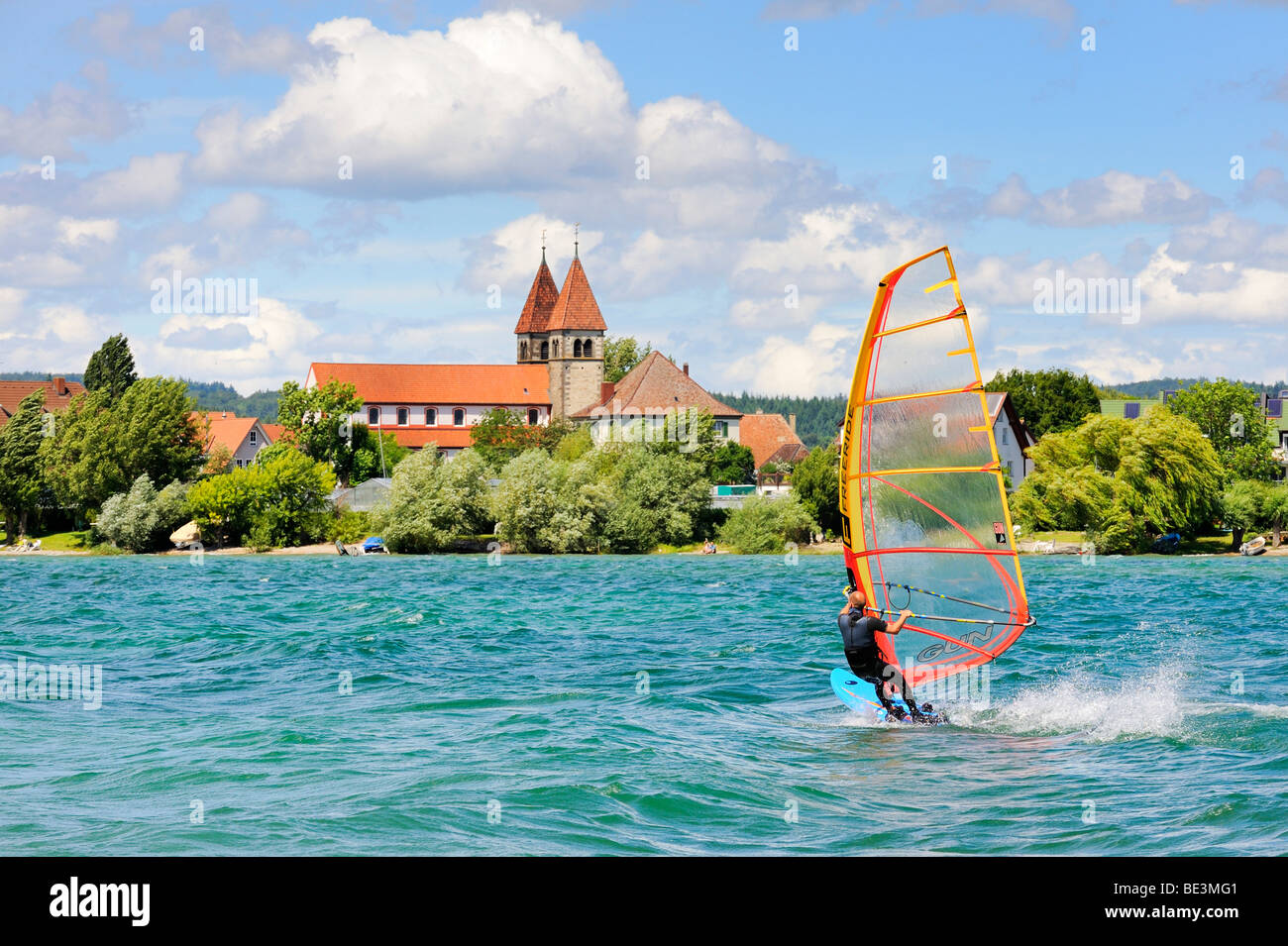 Windsurf sul Lago di Costanza, shore di Reichenau isola nel retro, San Pietro e la chiesa di San Paolo, nella contea di Costanza, Baden- Foto Stock