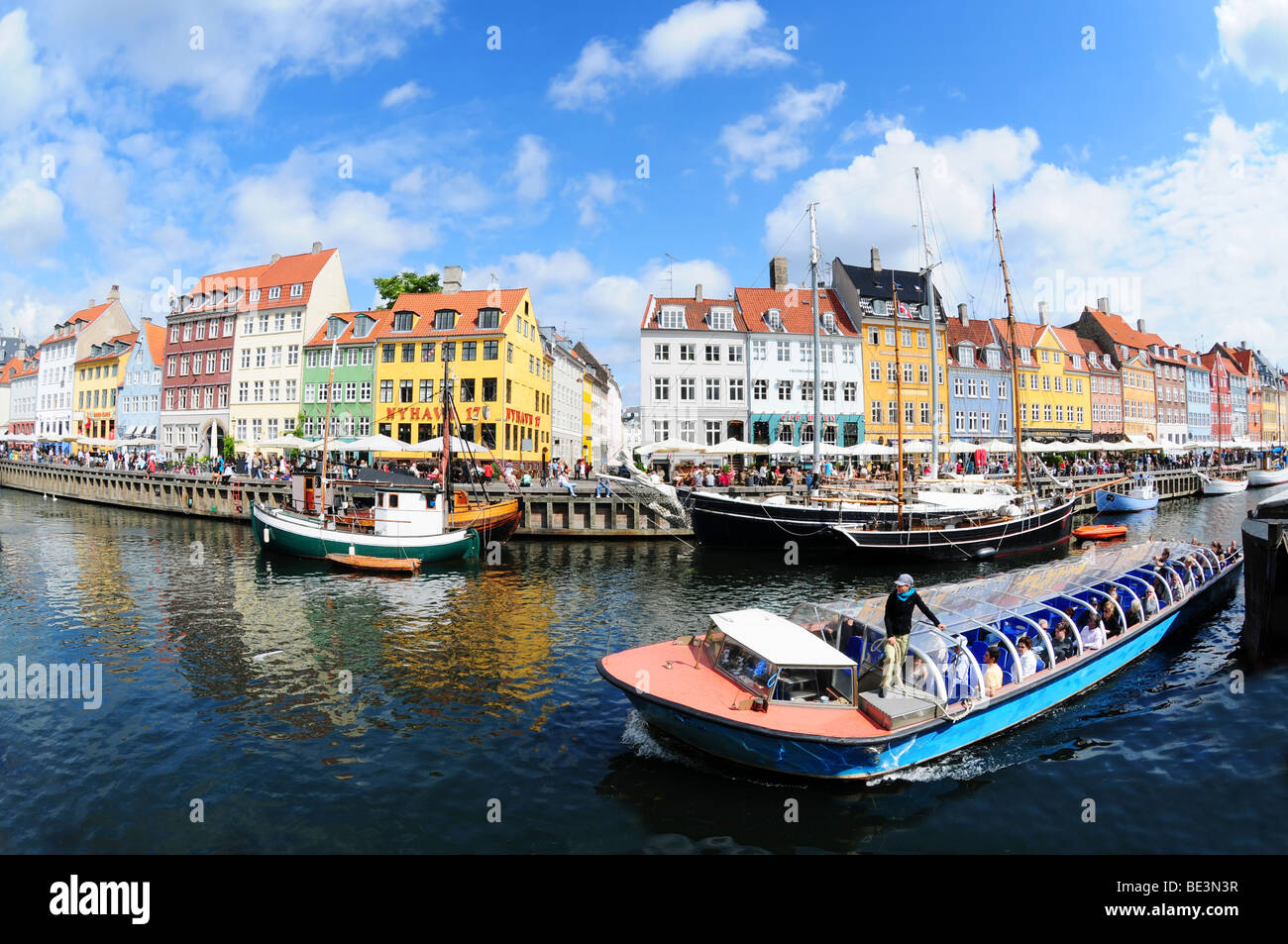 Vista fisheye su case colorate e tour in barca nel famoso canal Nyhavn a Copenaghen, Danimarca Foto Stock