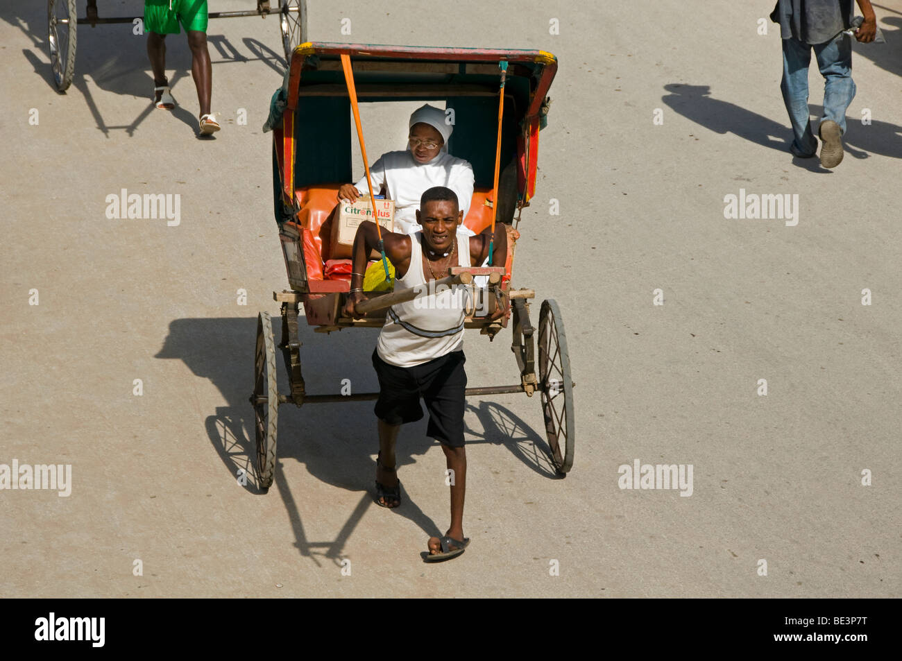 Pousse pousse guidatore e il suo passeggero in Tulear Madagascar Foto Stock