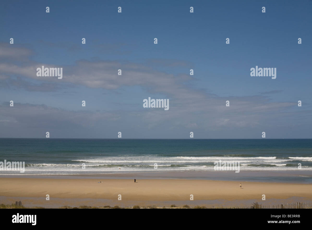 Un camminatore solitario sulla spiaggia, il mare e il cielo a Lacanau Ocean su Medoc costa vicino a Bordeaux in Francia Foto Stock