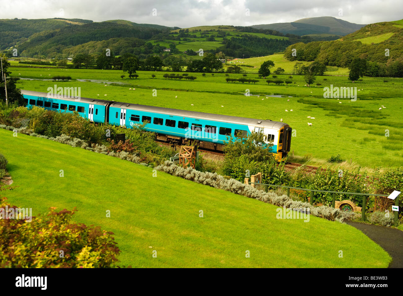 Arriva il Galles treno diesel che viaggiano lungo la linea ferroviaria nella valle Dyfi appena al di fuori di Machynlleth Powys Mid Wales UK Foto Stock