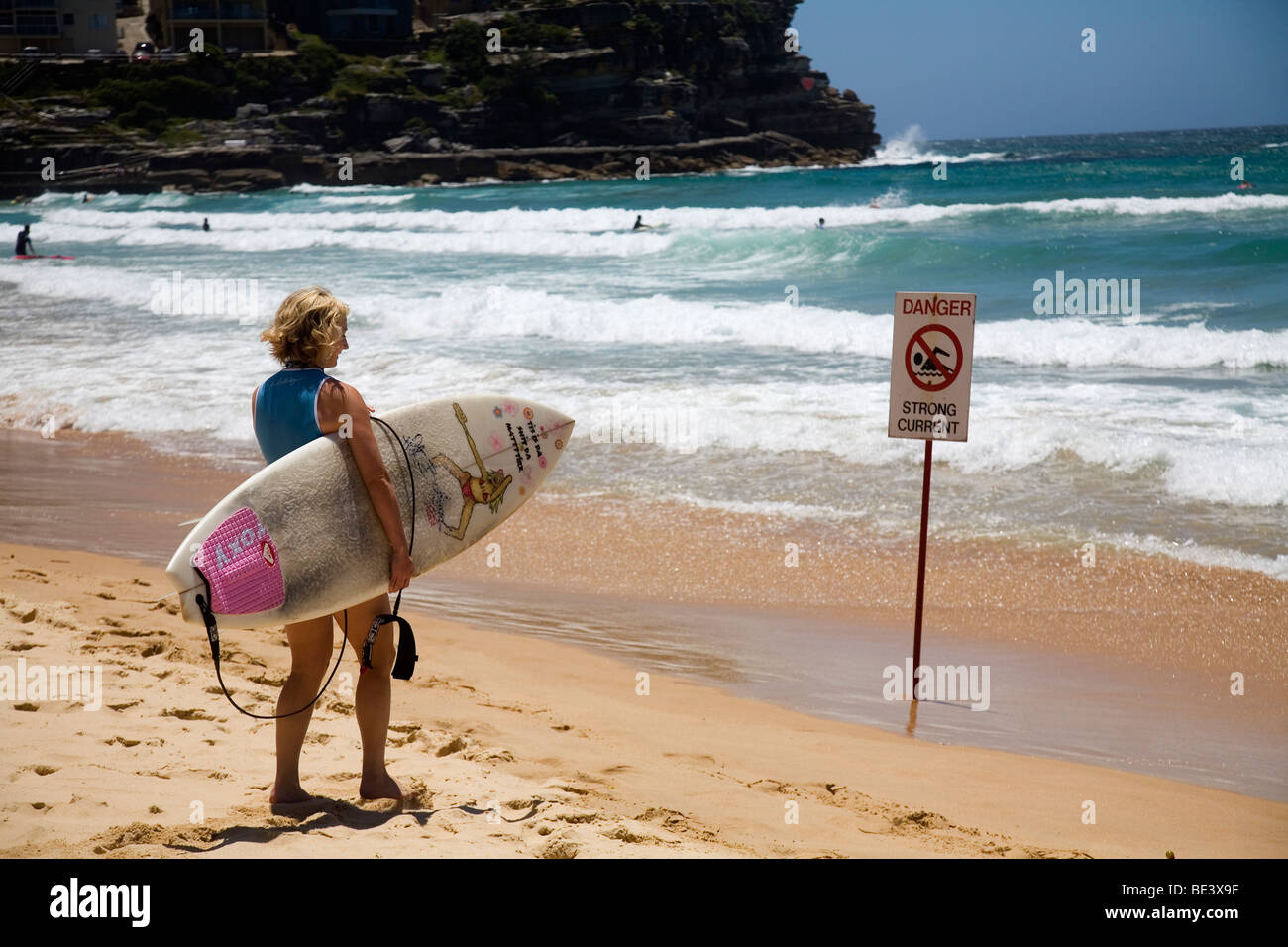 Un surfista femmina si affaccia alle onde a Manly Beach Sydney, Nuovo Galles del Sud, Australia Foto Stock