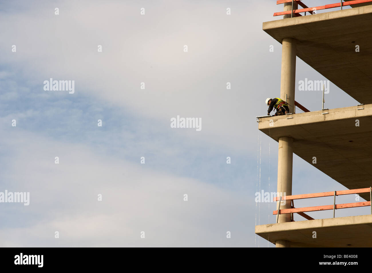 Operaio edile montaggio guide di sicurezza a s in parte costruito in blocco ufficio, Dusseldorf, Germania. Foto Stock