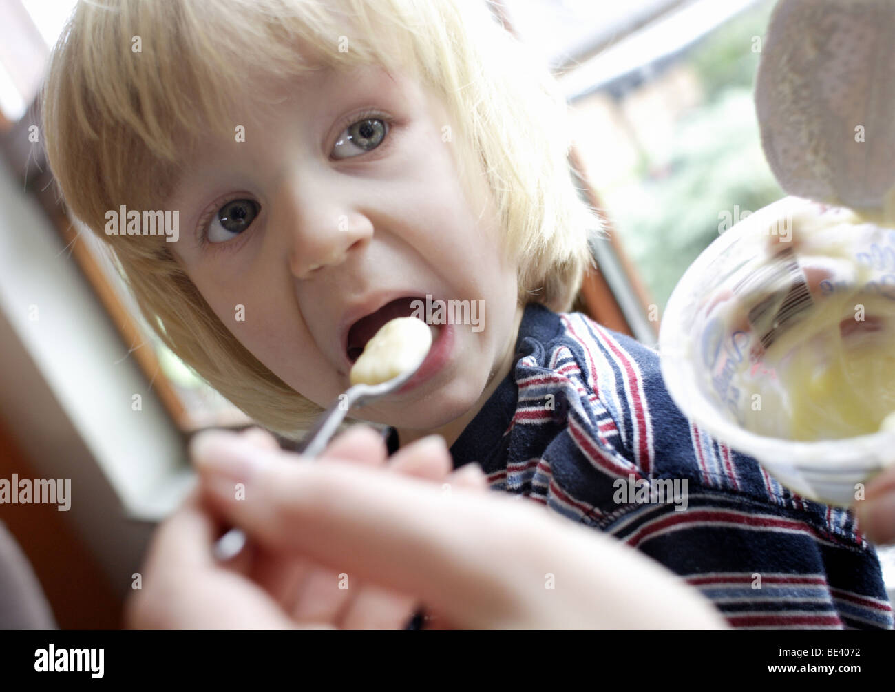 Ein Junge wird gefuettert Foto Stock