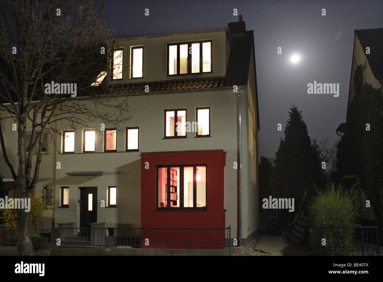 Haus mit Lichtern im Mondschein Foto Stock