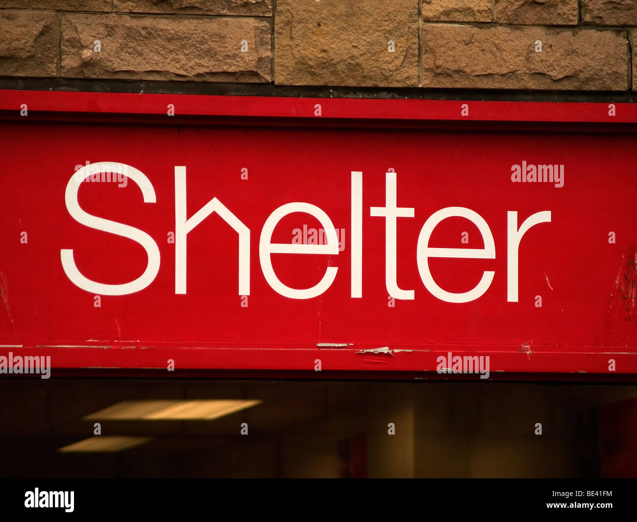 Shelter segno a una carità shop Foto Stock