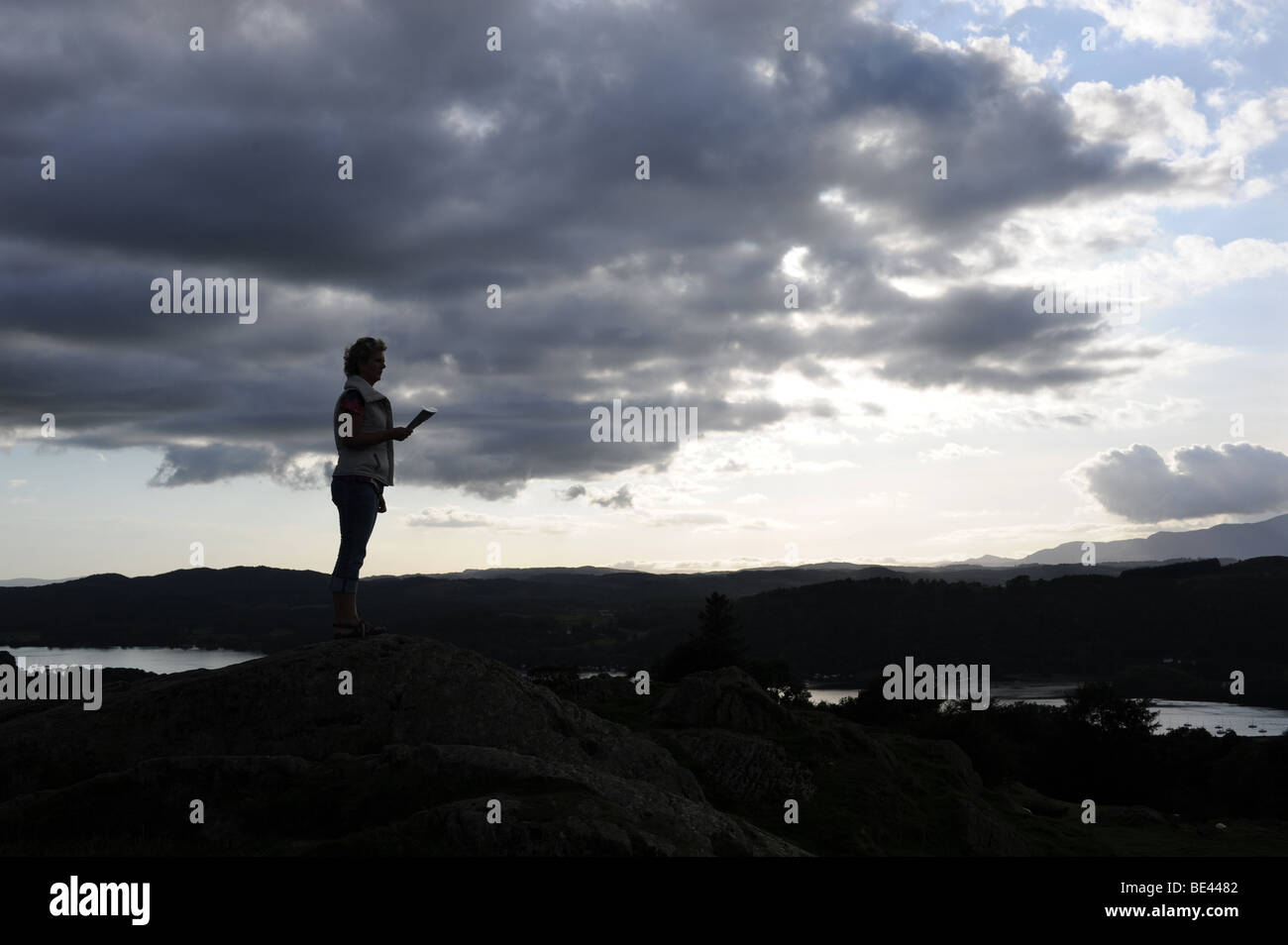 La donna sta al top della Brantfell sopra il Lago Windemere e la città di Bowness nel Lake District in Cumbria Regno Unito Foto Stock