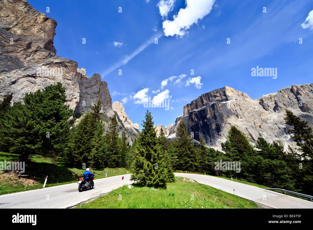 Motociclista di fronte al massiccio del Sella nelle Dolomiti, Italia, Europa Foto Stock