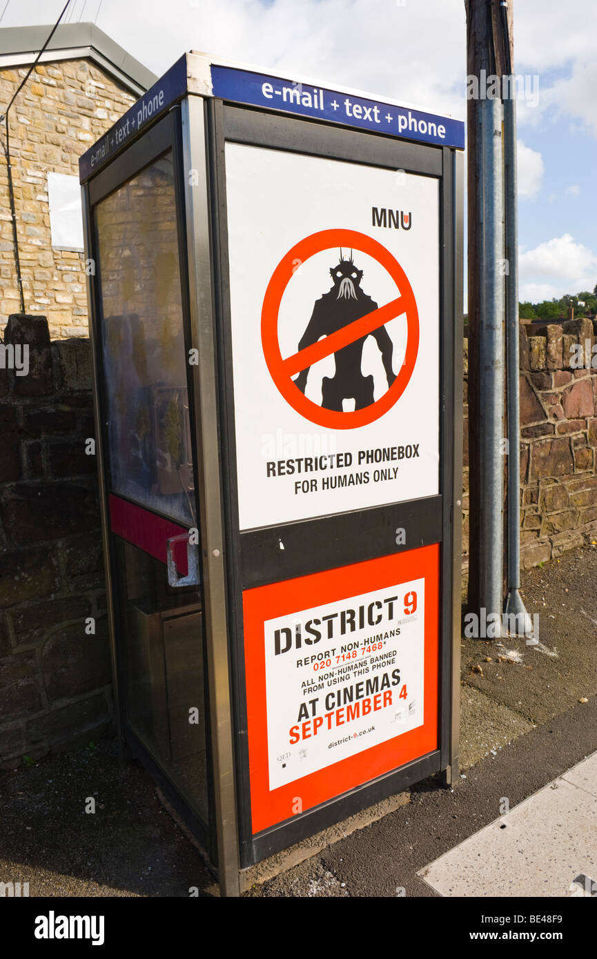 Affissioni per il Distretto 9 cinema sul telefono BT box in UK RESTRICTED PHONEBOX PER GLI ESSERI UMANI Foto Stock