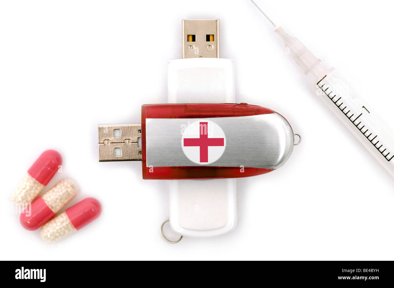Pen Drive con una croce rossa, ago da iniezione e compresse, immagine simbolica per mediche digitalizzate i dati paziente Foto Stock